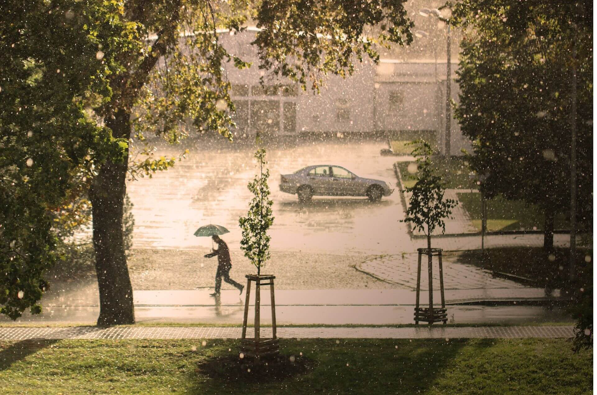 Homme qui marche dans la rue sur une forte pluie